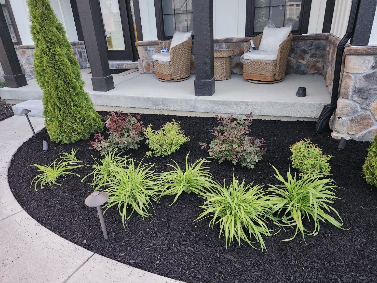 Finished dark mulch around established porch plants.